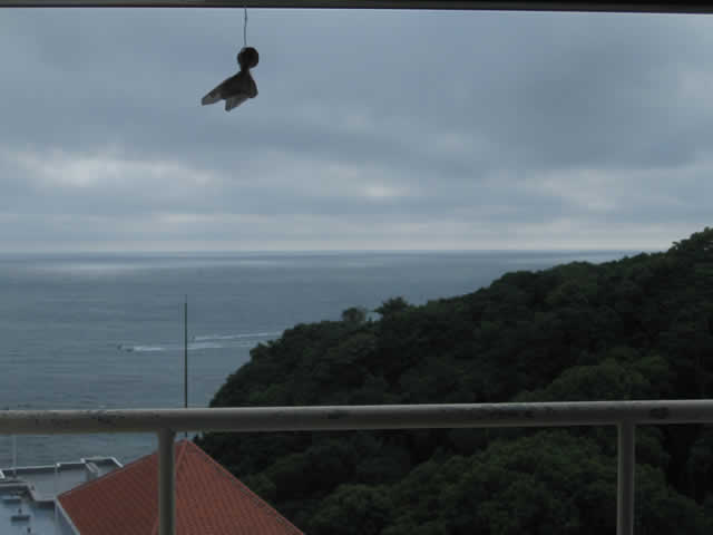 写真2：ホテルの部屋の窓の外は物憂げな曇り空です。雨が降りそうな写真です。