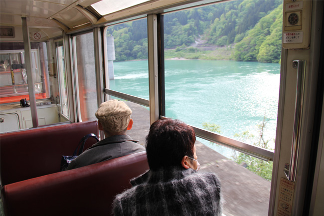 写真：黒部峡谷トロッコ電車の車窓を楽しむお客様