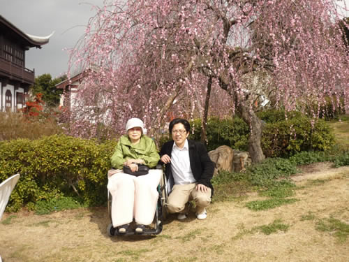 写真：梅の前でお客様とエスコートヘルパーで記念撮影