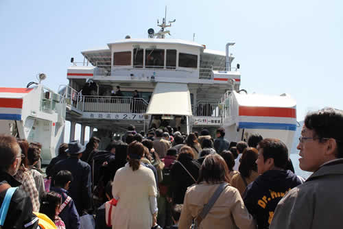 写真：大勢の観光客とともにフェリーに乗り込む