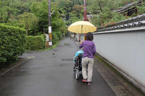 写真：雨が降る中、傘を持って移動